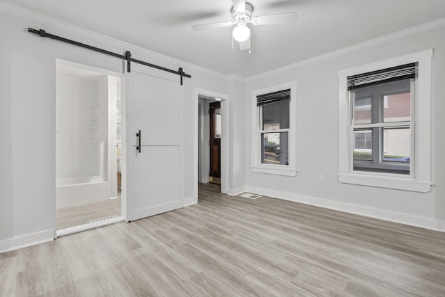 18 Brook St, Shelton, CT 06484 - empty room with a barn door, baseboards, ornamental molding, light wood finished floors, and ceiling fan