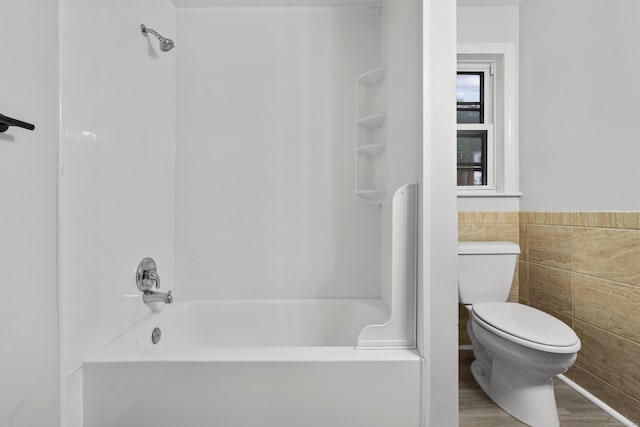 18 Brook St, Shelton, CT 06484 - bathroom featuring toilet, tile walls, wood finished floors, washtub / shower combination, and wainscoting