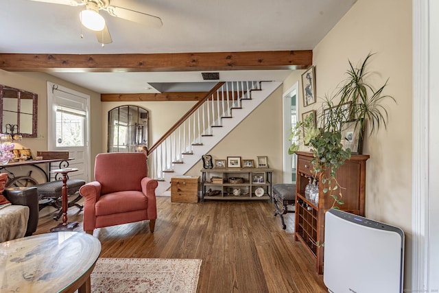 living area with dark wood-style flooring, stairs, beam ceiling, and visible vents