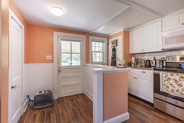 kitchen with white microwave, dark wood finished floors, white cabinetry, and stainless steel range with electric cooktop