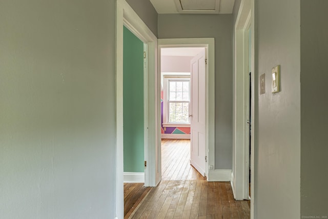 hallway with wood-type flooring and baseboards