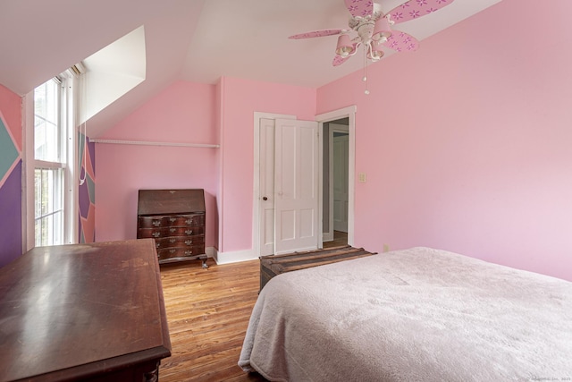 bedroom featuring vaulted ceiling, baseboards, a ceiling fan, and wood finished floors