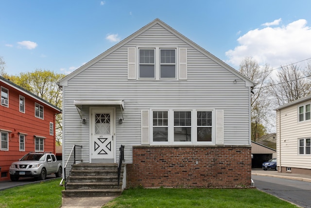 view of front of property featuring brick siding and a front yard