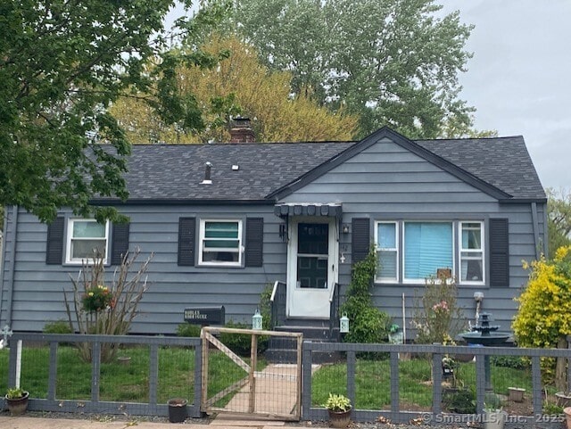 bungalow-style house with roof with shingles, a gate, a fenced front yard, and a chimney
