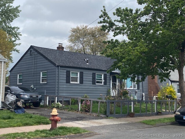 view of front of house with a fenced front yard and a shingled roof