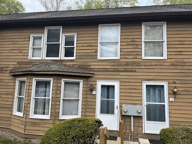 rear view of house with a shingled roof
