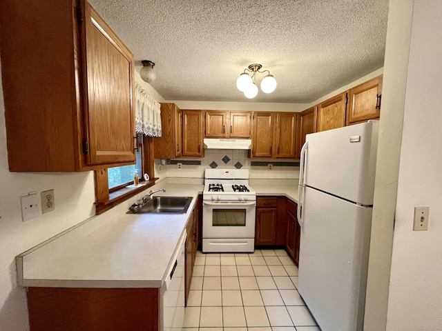kitchen featuring under cabinet range hood, brown cabinetry, white appliances, a sink, and tasteful backsplash