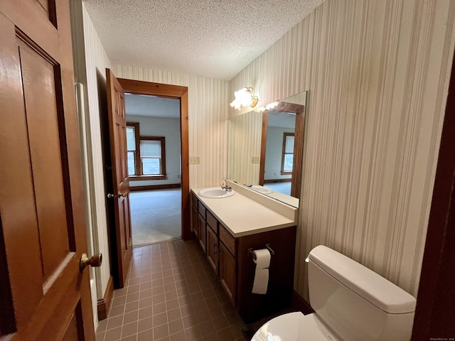 bathroom with vanity, a textured ceiling, and toilet