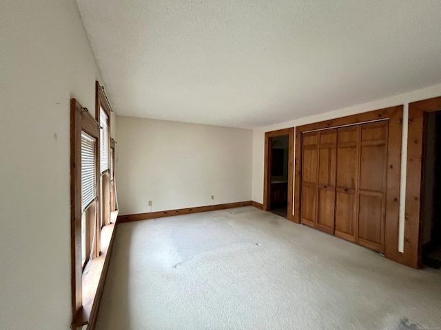 unfurnished bedroom with light carpet and baseboards