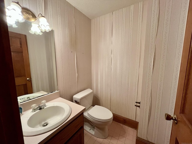 bathroom featuring wallpapered walls, toilet, tile patterned flooring, and vanity