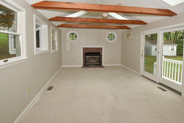 unfurnished living room featuring baseboards, a fireplace, carpet flooring, and a skylight