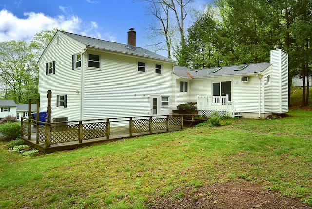 rear view of property with a wooden deck, a chimney, central AC unit, and a lawn