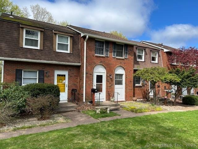 view of front of house with brick siding and a front yard