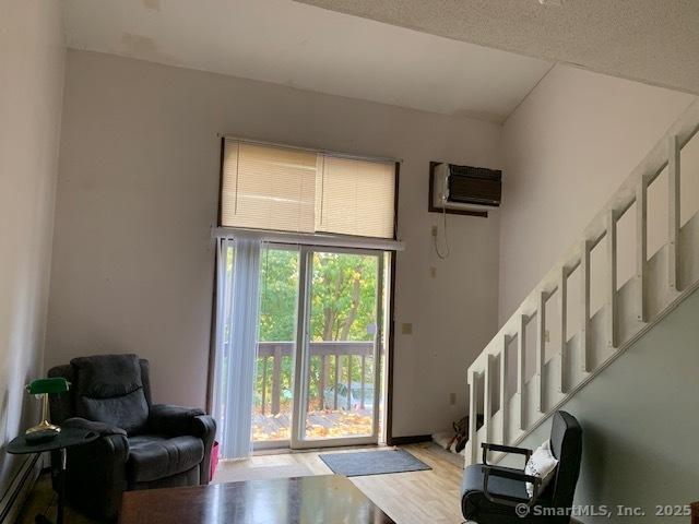 interior space featuring light wood finished floors, a wall mounted AC, and stairs
