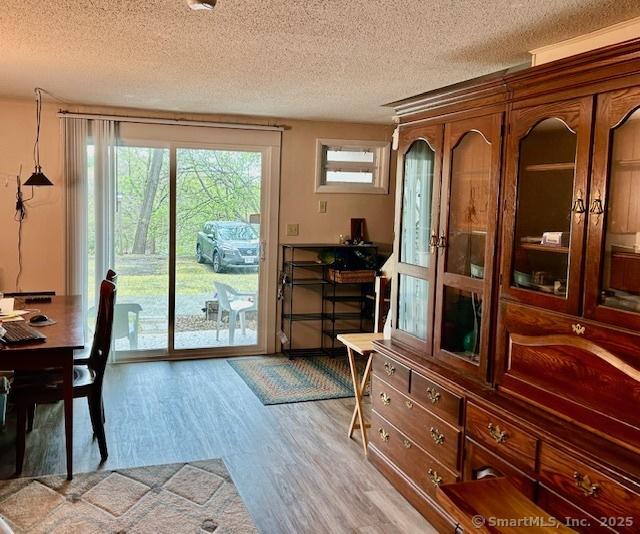 doorway with a textured ceiling and wood finished floors
