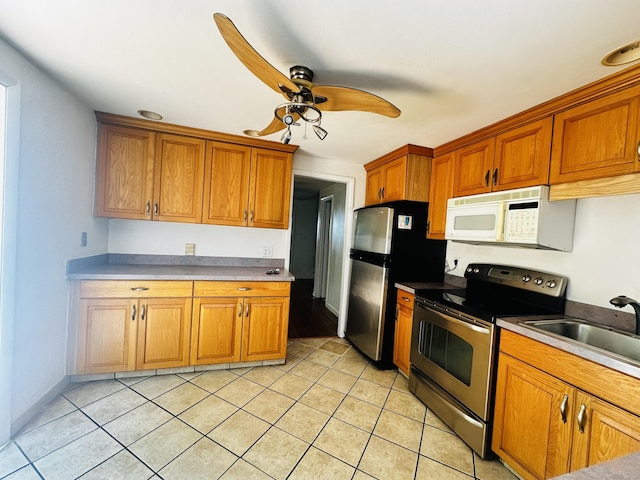5 N Ridgeland Rd, Wallingford, CT 06492 - kitchen with appliances with stainless steel finishes, a sink, a ceiling fan, light tile patterned floors, and brown cabinets