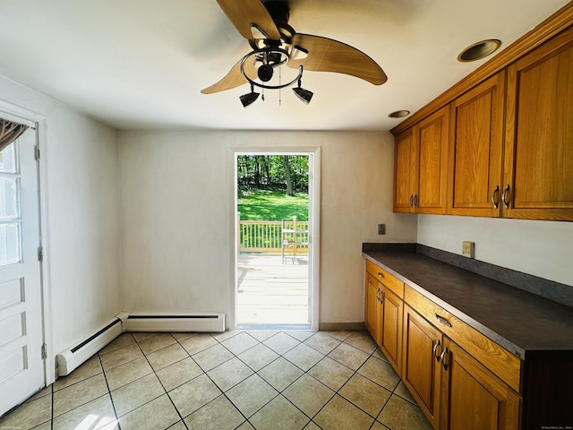 5 N Ridgeland Rd, Wallingford, CT 06492 - kitchen with dark countertops, brown cabinets, a ceiling fan, light tile patterned flooring, and a baseboard radiator