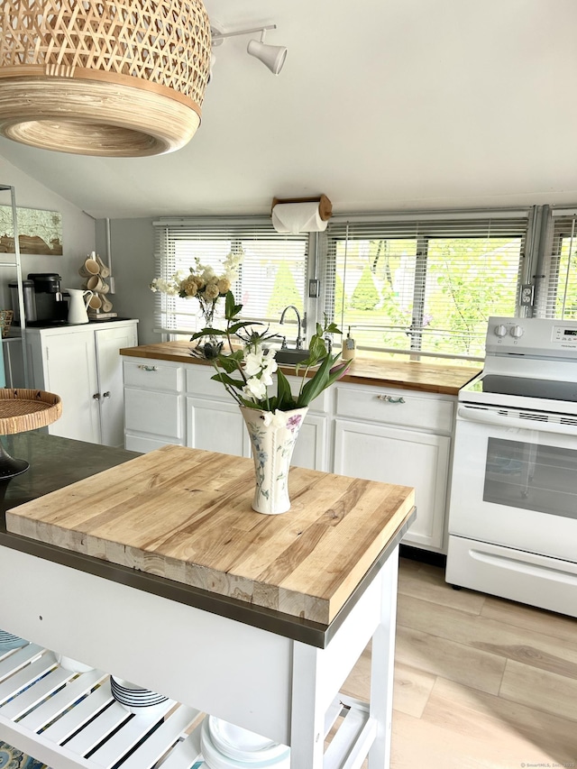 1 4th St, Madison, CT 06443 - kitchen with wood counters, white electric range oven, white cabinetry, light wood finished floors, and plenty of natural light