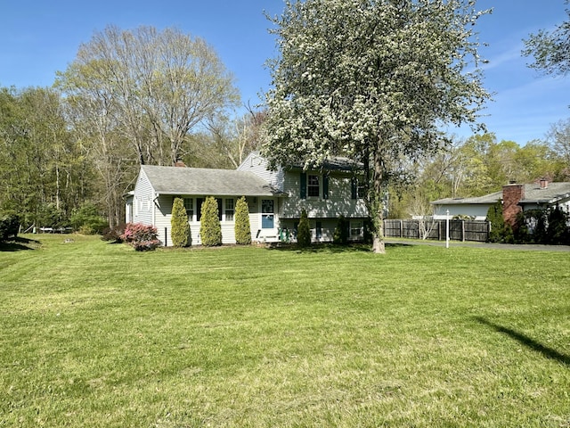 76 Chidsey Dr, North Branford, CT 06471 - view of front of house with roof with shingles, fence, a front lawn, and a chimney
