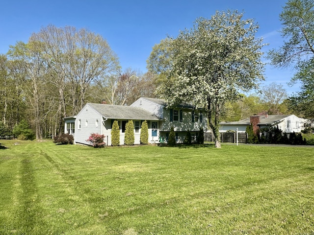 76 Chidsey Dr, North Branford, CT 06471 - view of front of home featuring fence, a shingled roof, a front lawn, and a chimney