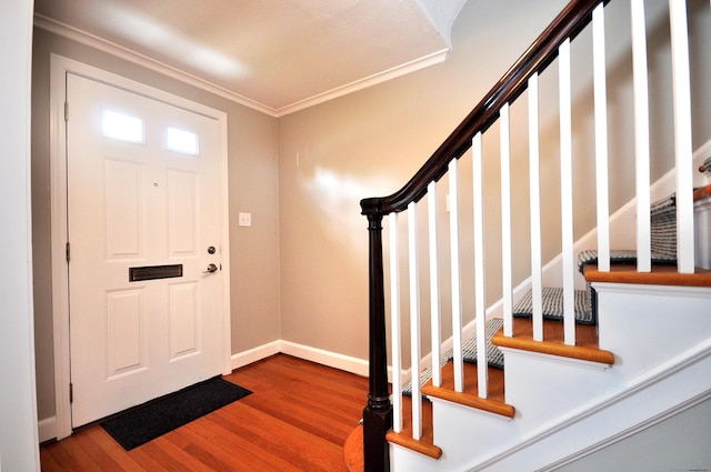 foyer featuring baseboards, stairs, ornamental molding, and wood finished floors