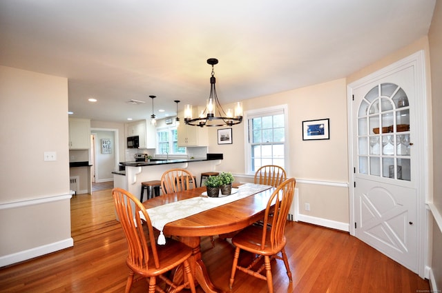 dining space featuring an inviting chandelier, recessed lighting, baseboards, and light wood-style floors