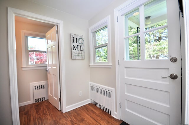 doorway featuring baseboards, radiator heating unit, and dark wood finished floors