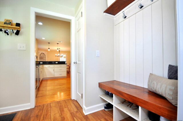 mudroom with light wood finished floors, baseboards, a chandelier, and recessed lighting