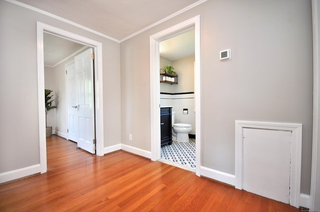 unfurnished bedroom featuring crown molding, wood finished floors, and baseboards