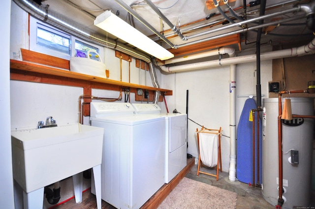 laundry room with laundry area, water heater, a sink, and washing machine and dryer