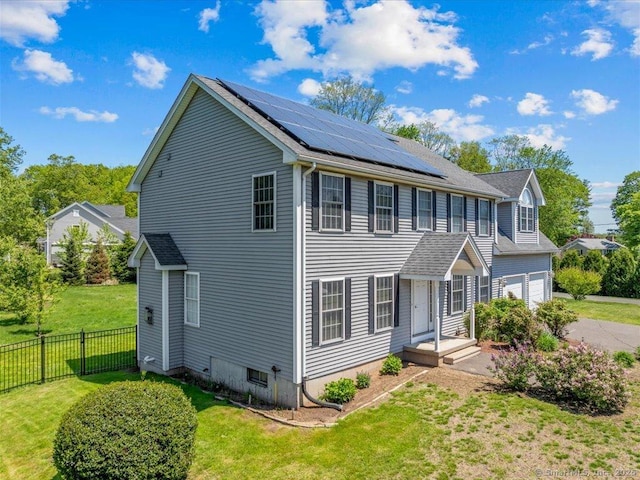 149 Tromley Rd, East Windsor, CT 06088 - view of front facade featuring roof mounted solar panels, an attached garage, and driveway