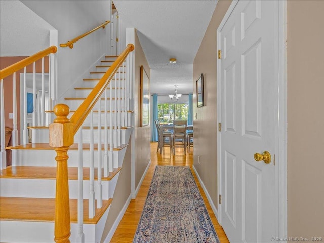 149 Tromley Rd, East Windsor, CT 06088 - corridor with stairway, wood finished floors, a textured ceiling, and baseboards
