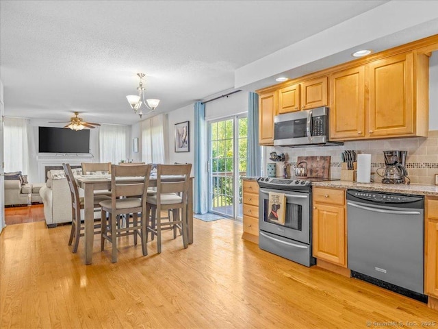 149 Tromley Rd, East Windsor, CT 06088 - kitchen with appliances with stainless steel finishes, light wood-style flooring, ceiling fan, decorative backsplash, and a chandelier