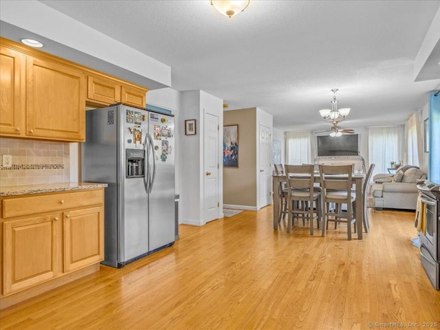 149 Tromley Rd, East Windsor, CT 06088 - kitchen with stainless steel appliances, a chandelier, light wood finished floors, backsplash, and baseboards