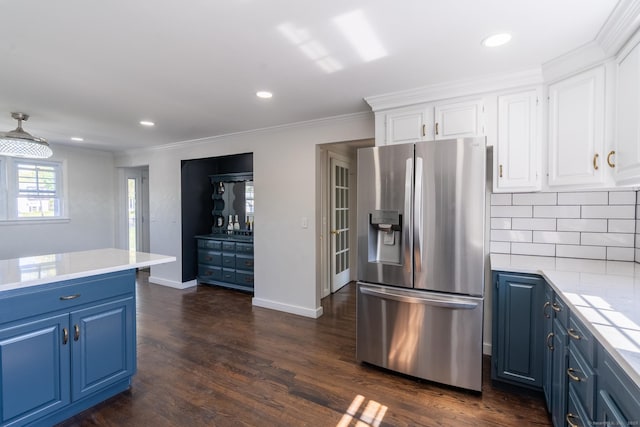 kitchen with light countertops, white cabinetry, stainless steel fridge, and blue cabinetry