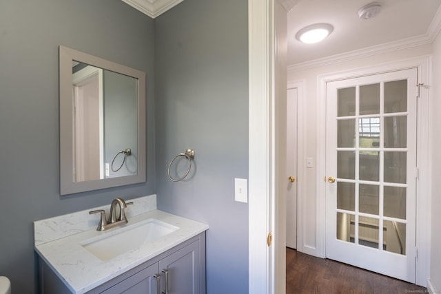 bathroom featuring wood finished floors, vanity, and ornamental molding