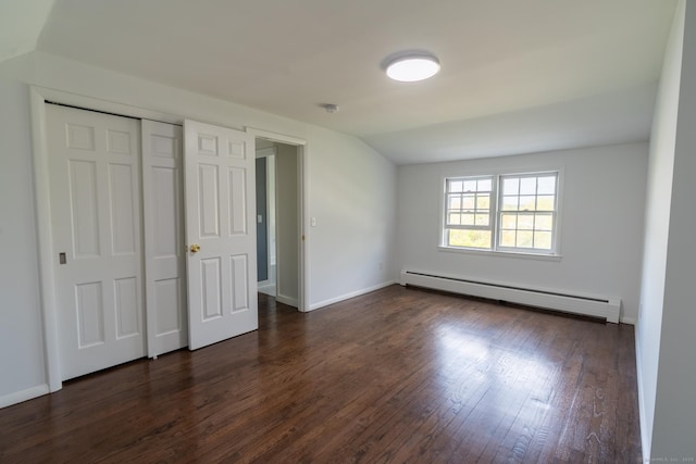 unfurnished bedroom with a baseboard radiator, baseboards, dark wood-type flooring, and a closet