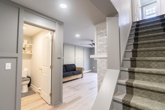 stairway featuring ceiling fan, recessed lighting, and wood finished floors