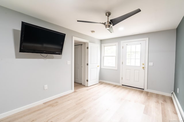 interior space featuring baseboards, light wood-style floors, baseboard heating, and a ceiling fan