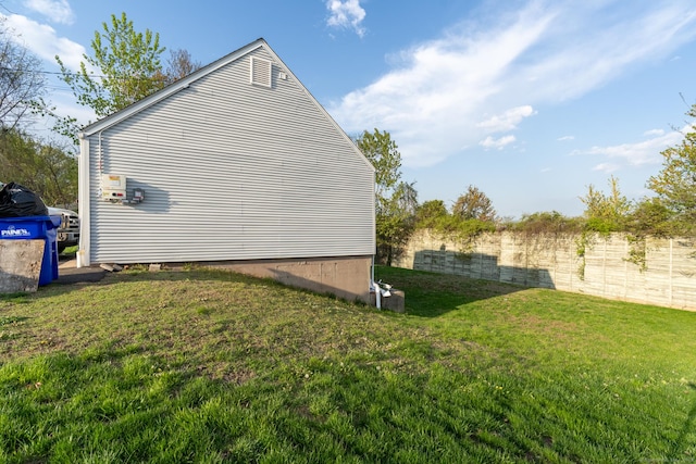 view of side of property with fence and a lawn