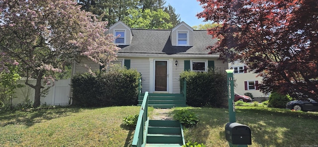 new england style home with a front lawn and a shingled roof