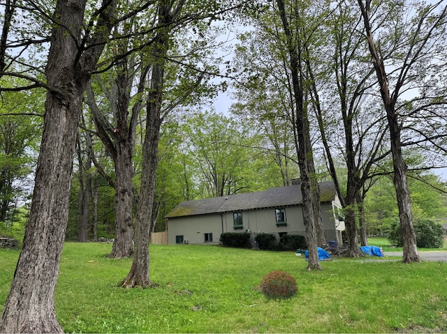 view of front of house with roof with shingles and a front yard