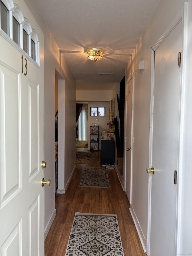 hallway with baseboards and wood finished floors