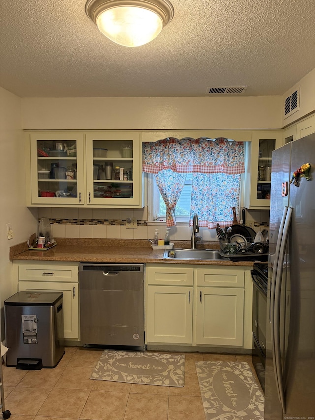 kitchen featuring visible vents, a sink, a textured ceiling, and appliances with stainless steel finishes