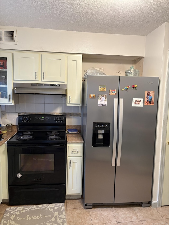 kitchen with stainless steel fridge, black electric range oven, under cabinet range hood, and white cabinetry