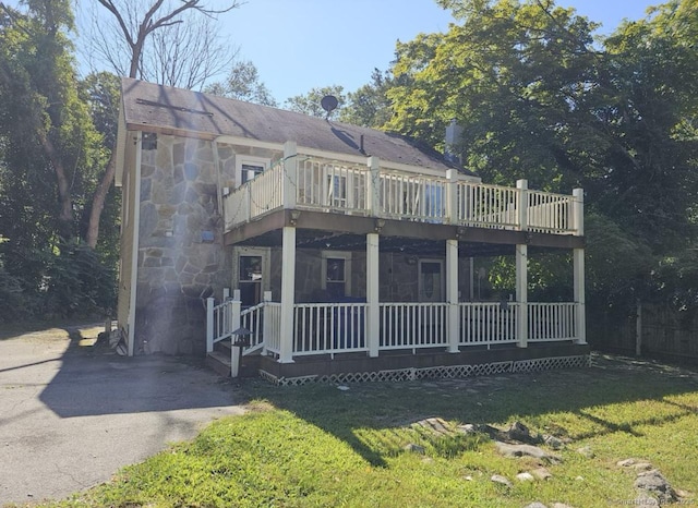 1067 Hartford Tpke, Waterford, CT 06385 - view of front facade featuring a front lawn, a balcony, and stone siding