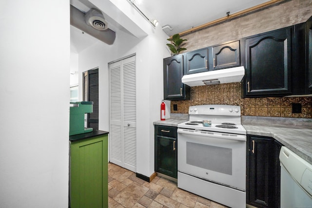 kitchen with stone finish flooring, backsplash, under cabinet range hood, and white appliances