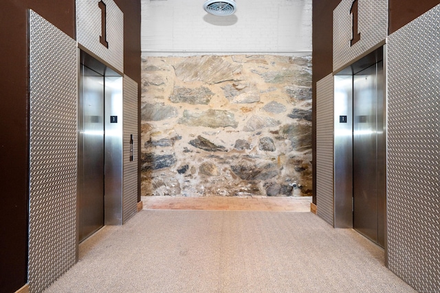 corridor with carpet flooring and elevator
