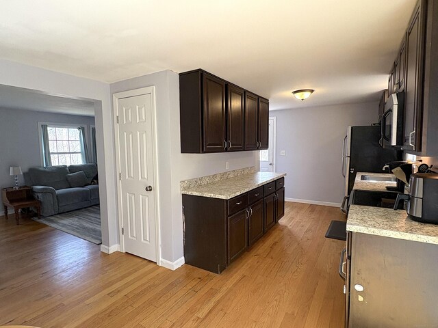161 Old New London Rd, Salem, CT 06420 - kitchen featuring baseboards, light countertops, light wood-style flooring, and dark brown cabinetry