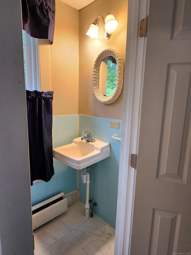 bathroom featuring a baseboard heating unit, tile walls, and wainscoting